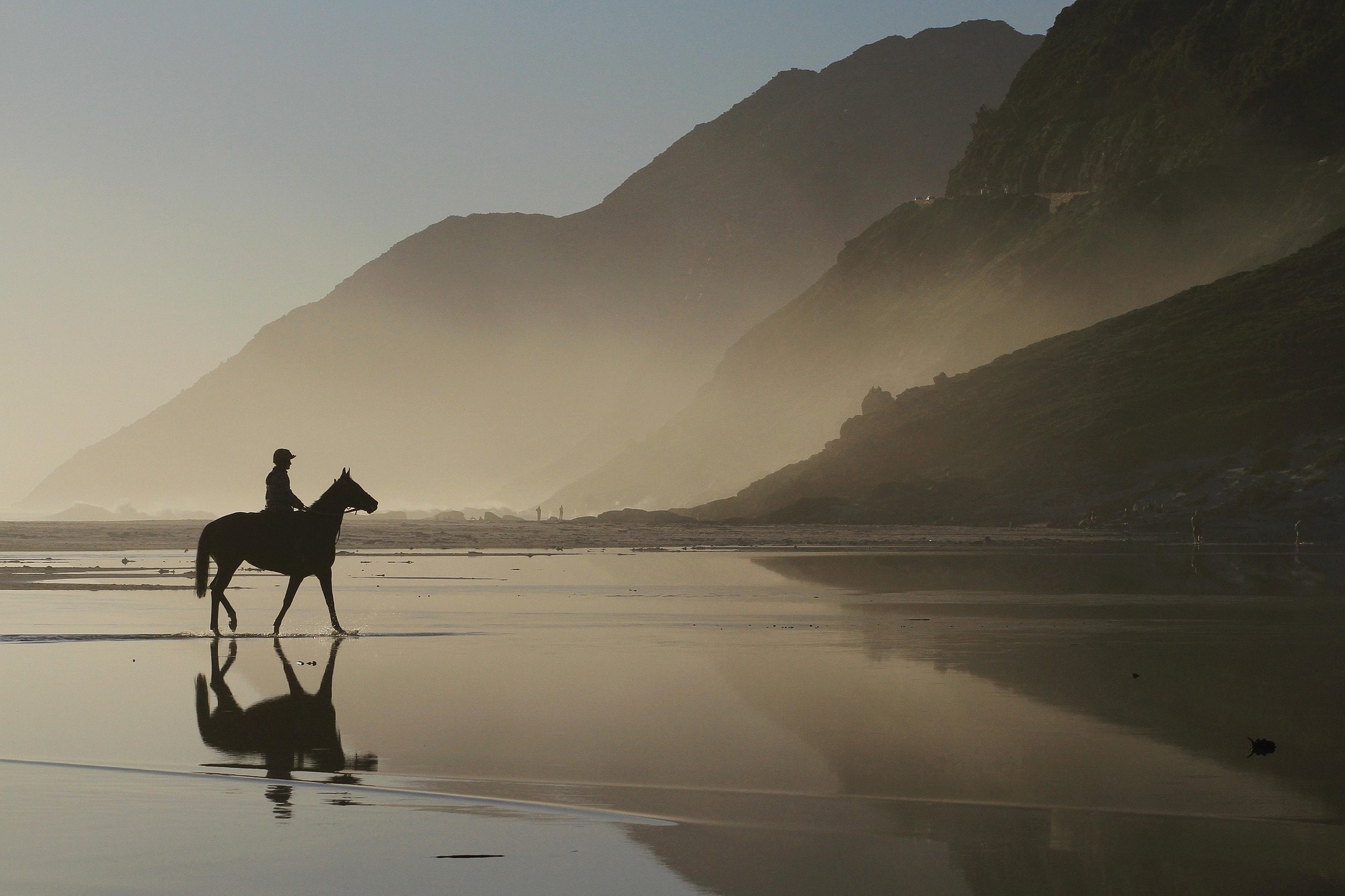 A man on the horse next to stunning mountains